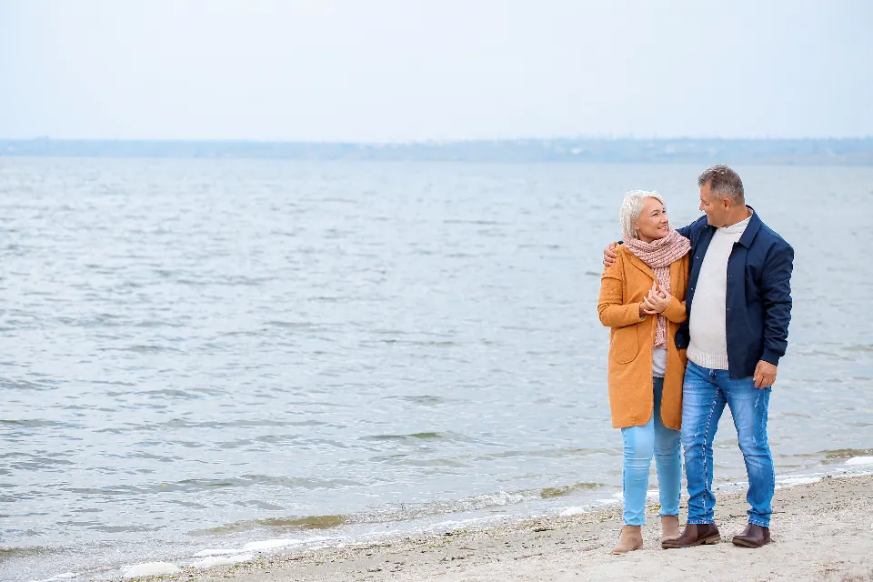 An older couple walking together on a beach